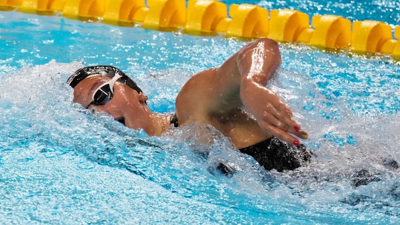 A swimmer races in the pool.