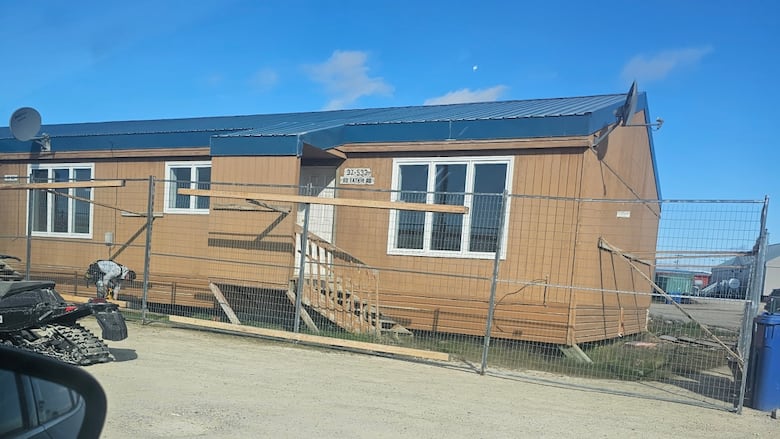 A row of brown housing units with small slanted pillars underneath 
