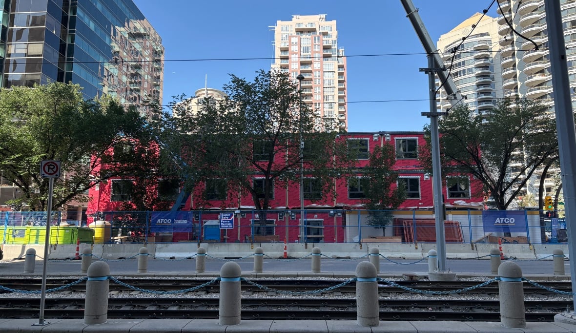 From across the street, a multi-residential modular building being construction. It's pink on the outside and is, so far, three storeys tall.