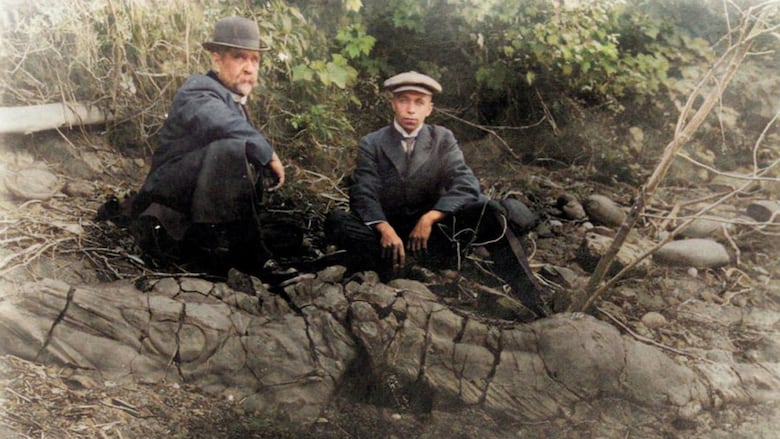 Two men pose with a fossil from 1916.