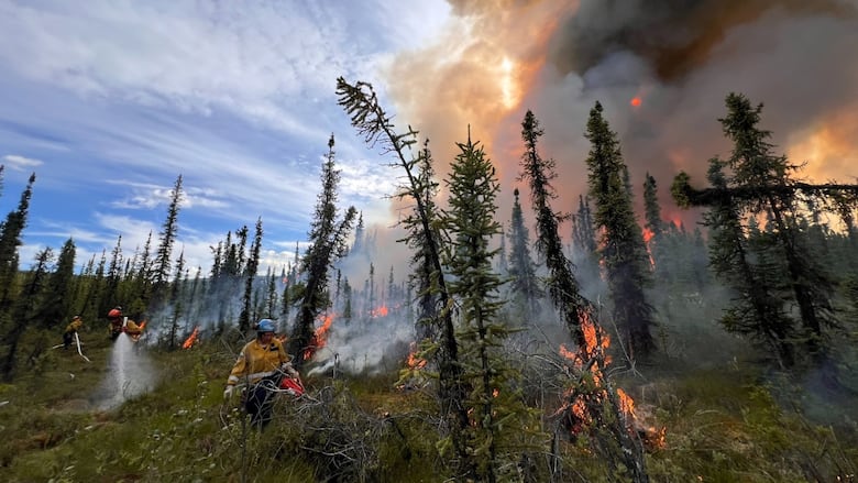 Firefighters work in the midst of flames and smoke.