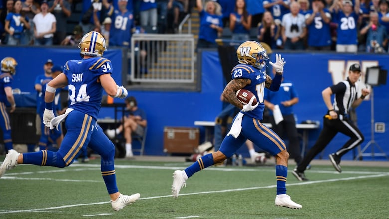 A player in blue and gold runs with the football.
