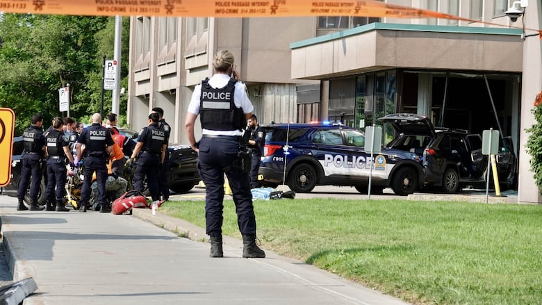 Police and first responders tend to a victim and a vehicle is seen after crashing into a building.