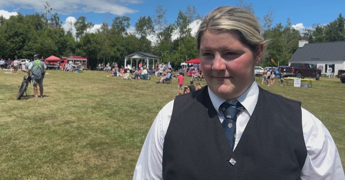 A woman in a vest and tie.