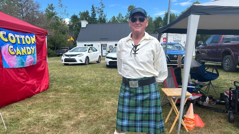 A man in a white shirt and kilt.