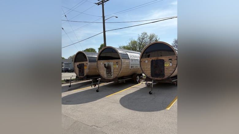 A picture of three saunas made out of cedar and in the shape of a barrel.