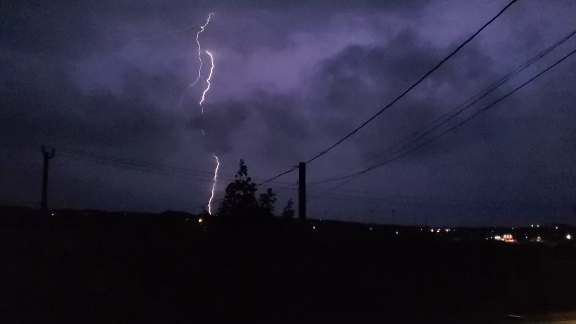 Purple and black sky with bolt of lightning