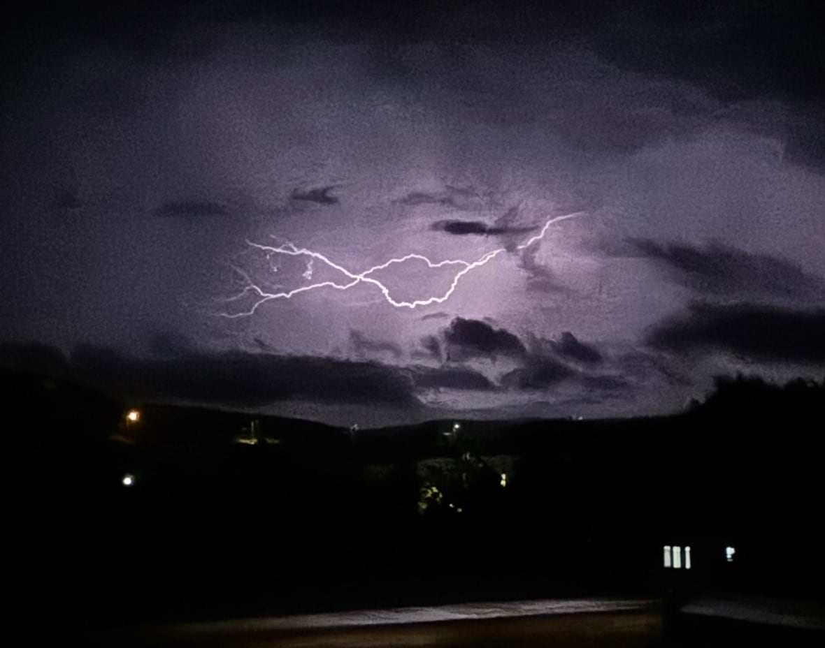 Purple and black sky with bright bolt of lightning