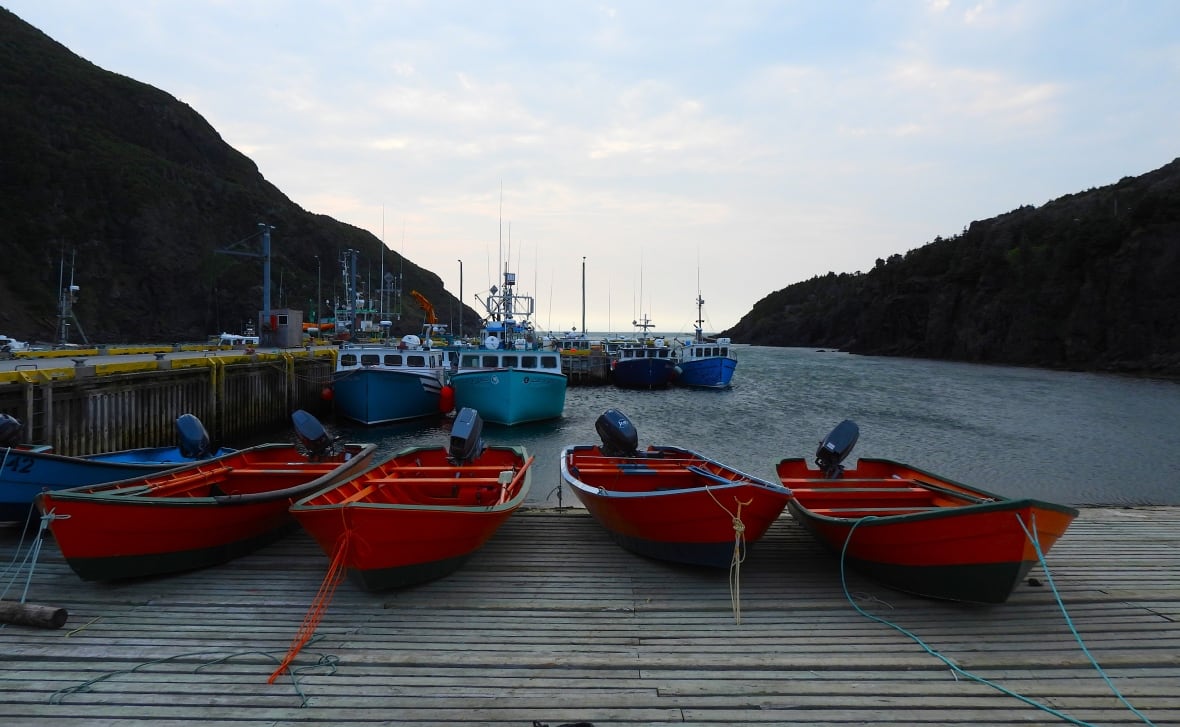 Four orange boats on wooden dock