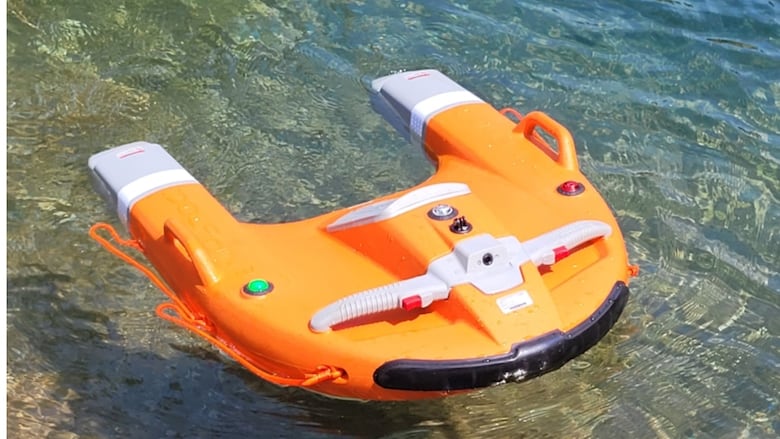 A bright orange small remote controlled water craft is shown.