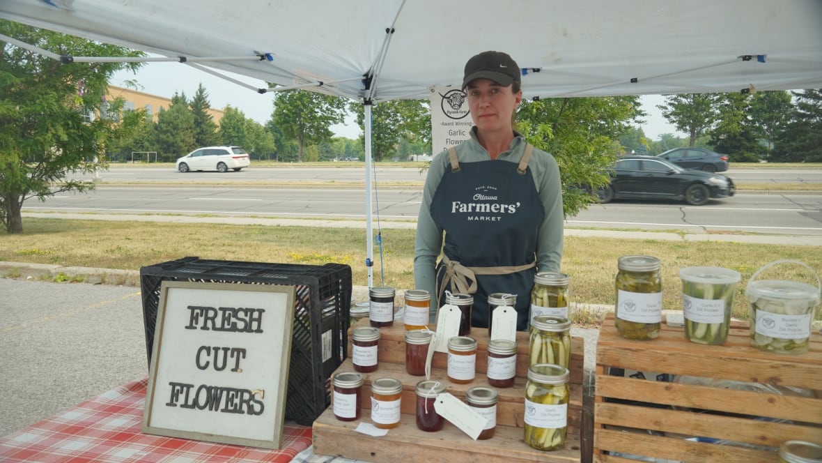 A woman at a farmers' market stand.