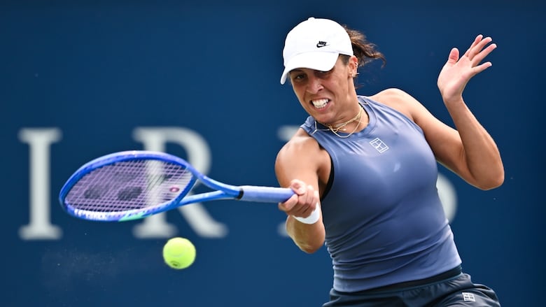 A women's tennis player hits a forehand shot.