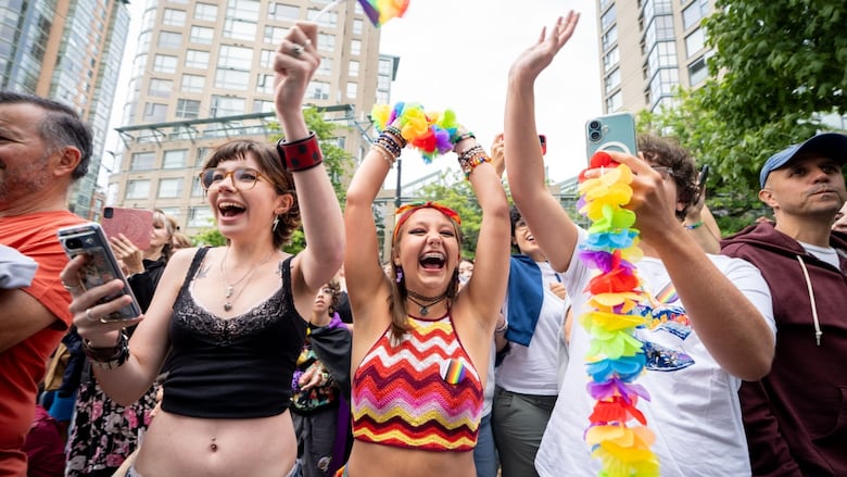 Paradegoers cheer and wave rainbow flags during the Vancouver Pride Parade on Sunday, celebrating with colourful outfits and messages of love and inclusion. 