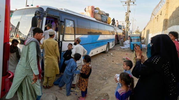 Afghan refugees board a bus to leave for their homeland Afghanistan.
