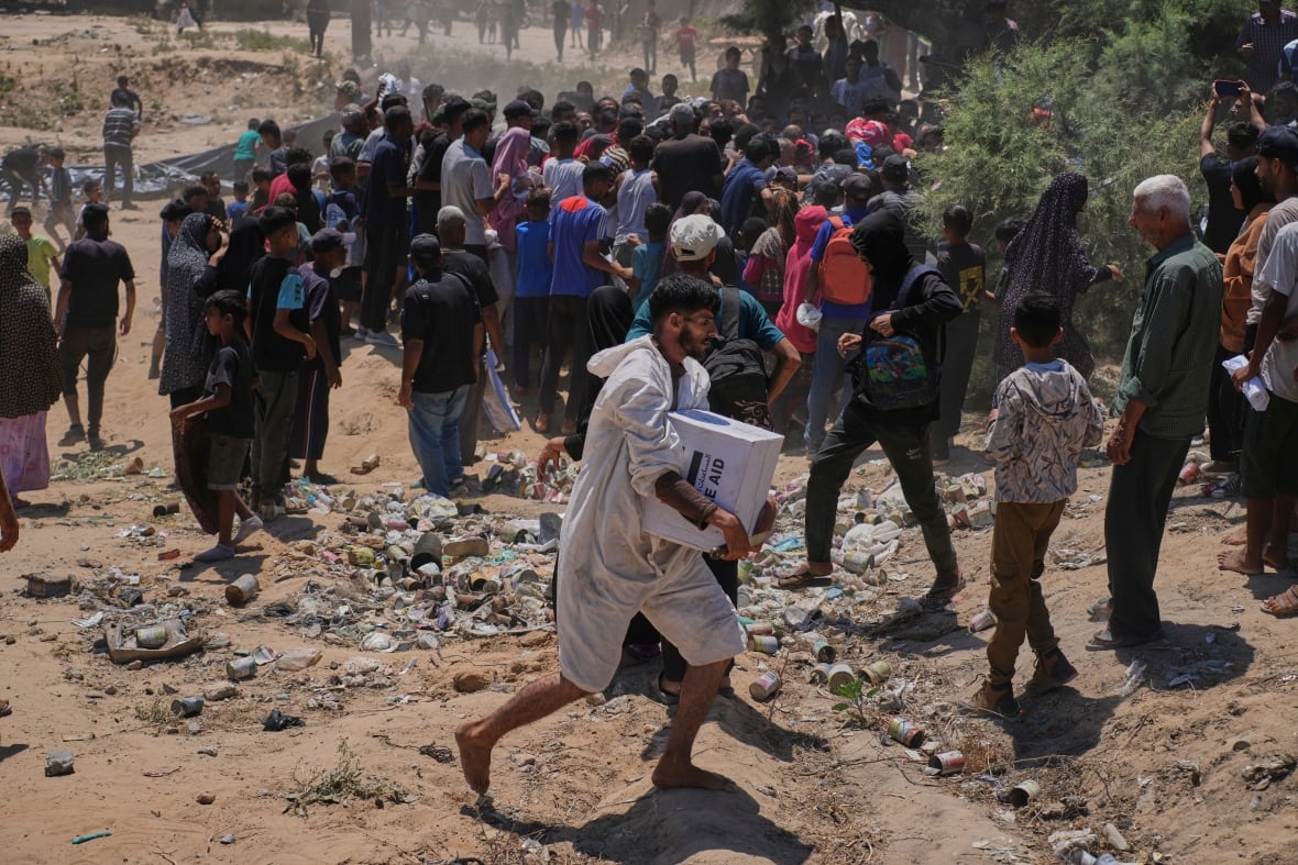 People rush to pick up and carry aid.