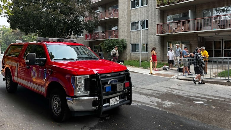 Fire vehicle and people outside an apartment building