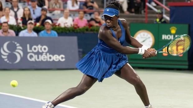 A tennis player hits a ball.