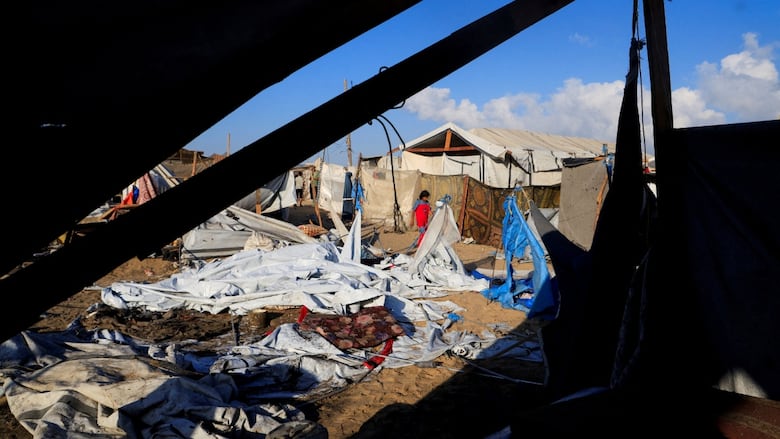 A child walks through a make-shift tent camp.