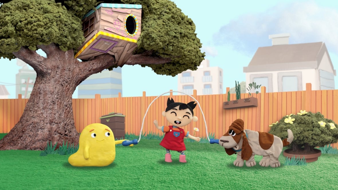 An animated image show a dog and a yellow blob-like alien holding a jump rope while a young girl skips in a backyard. 