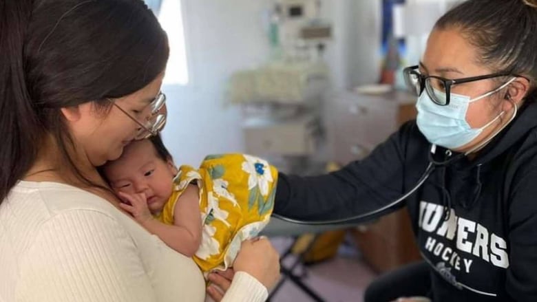 A Cree midwife caretaking for a mother and her baby. 