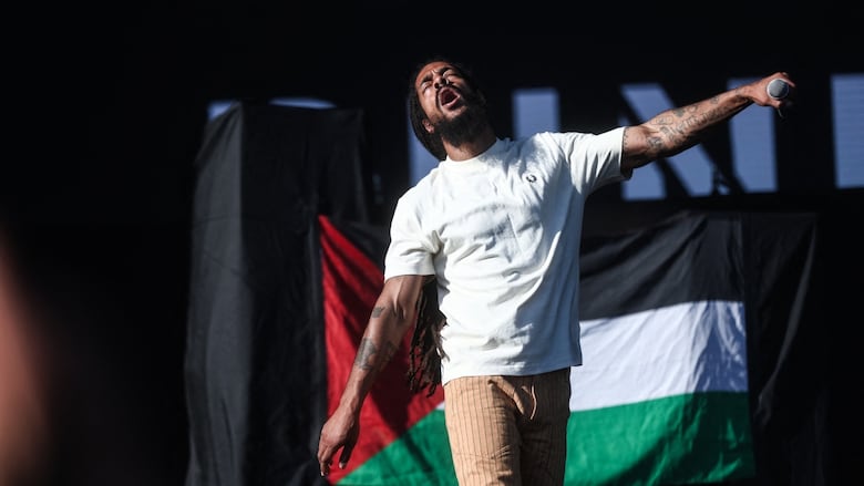 Bobby Vylan of Bob Vylan performs next to a Palestinian flag at Release Athens Festival 2025, on July 4, 2025  in Athens, Greece. 
