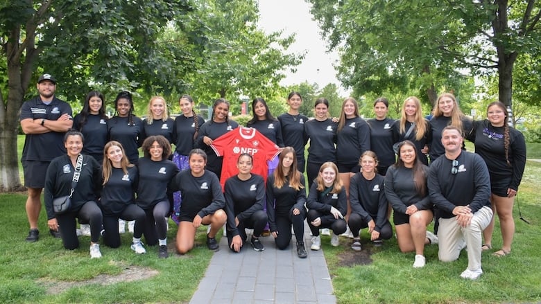 A team of rugby players poses for a photo.