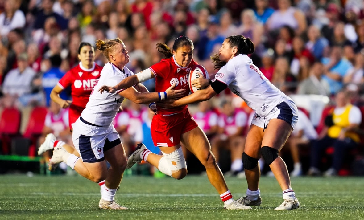 A rugby player breaks a tackle.
