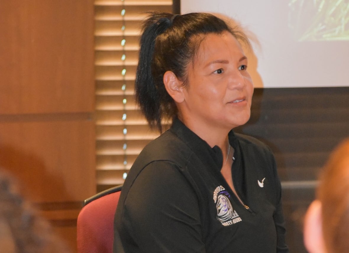 A woman speaks to a group of people.