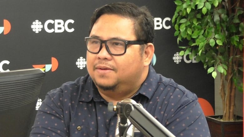 A man sitting in front of a mic.
