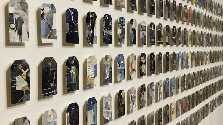 Dozens of shipping tag collages mounted on a wall. 