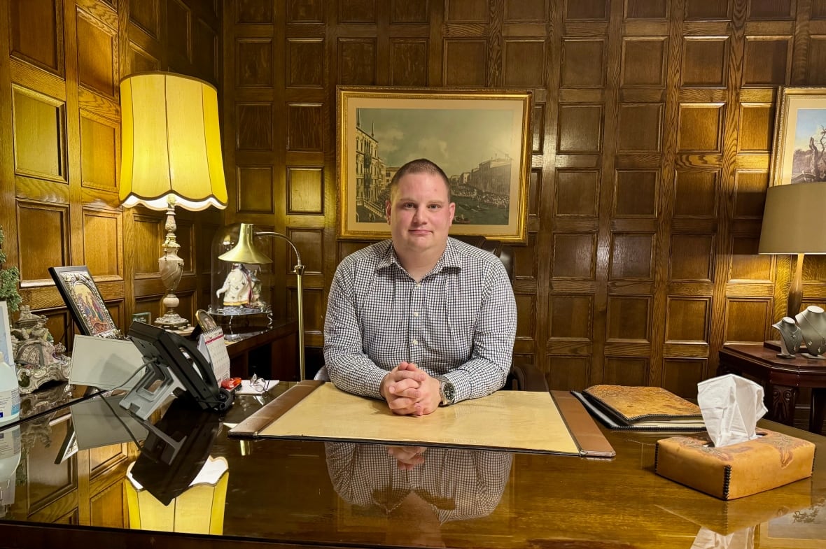 Man sitting at wood desk.
