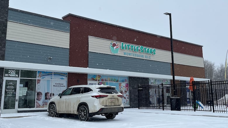 A view of a building with a sign that says Little Stars Montessori ELC with snow on the ground outside.