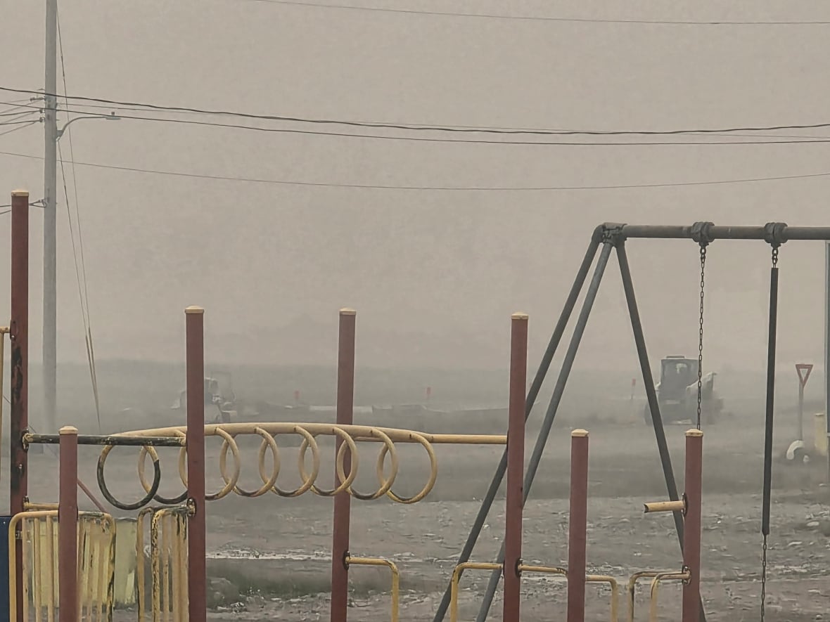 A hazy sky blurring out a playground and work equipment in the background.