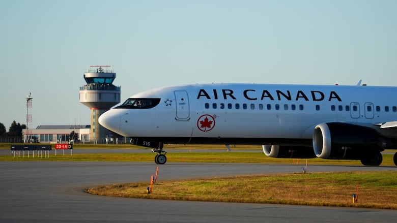 The nose of an Air Canada plane on the tarmac is visible. 