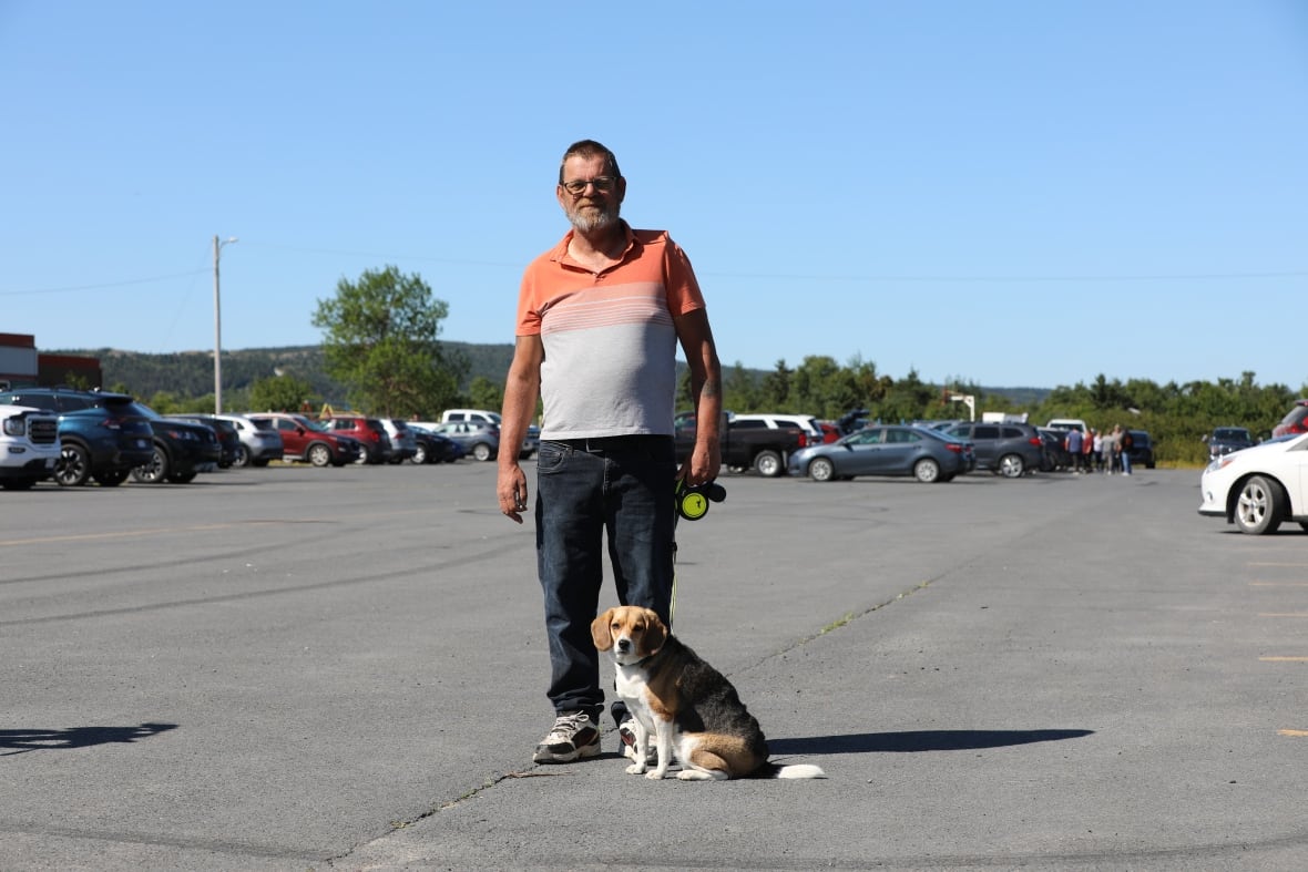 Man with dog on leash in parking lot