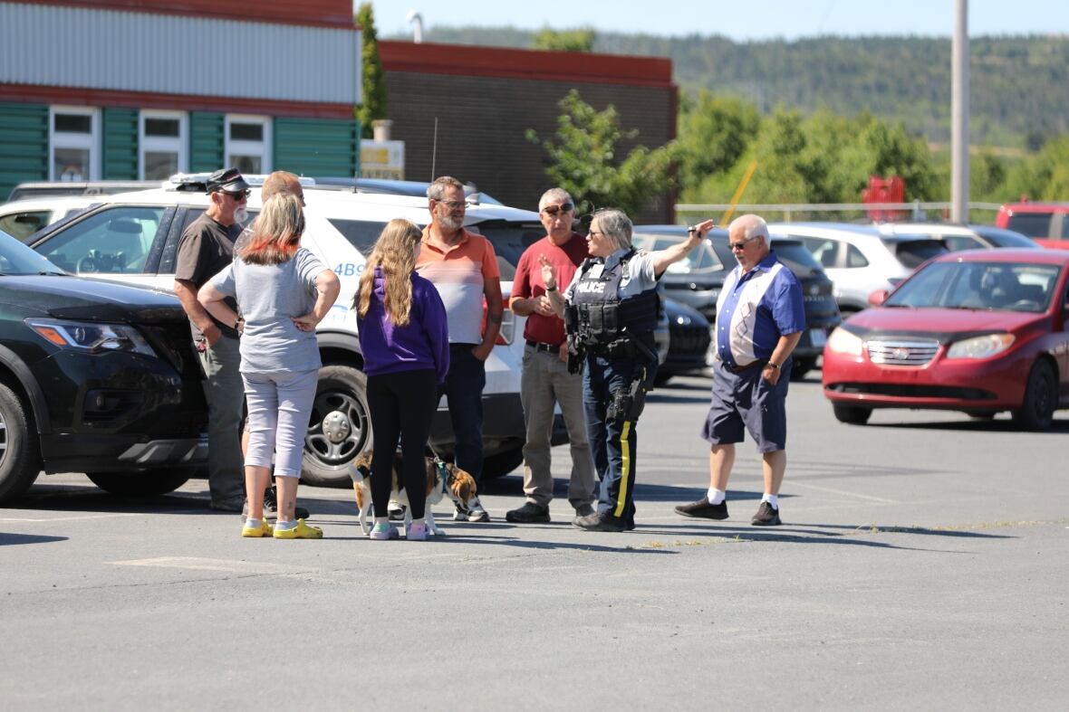 Crowd of people talking to police officer