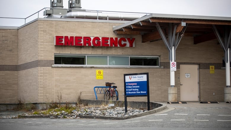 The word 'Emergency' is written in red letters on a small building, with a sign pointing to other hospital areas below it.