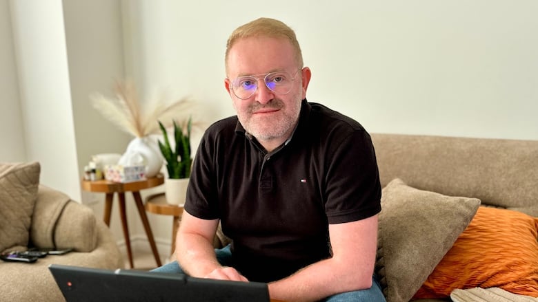 man sits at laptop in living room