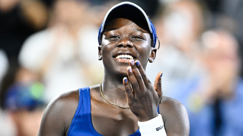 A woman tennis player smiles.