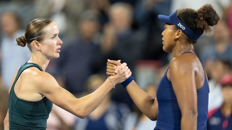 Two women's tennis players are shown slapping hands after a match.