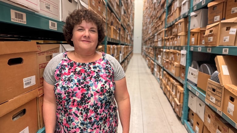 Anne Quirk, an archivist at Western University, stands in an aisle of the school's archive warehouse.