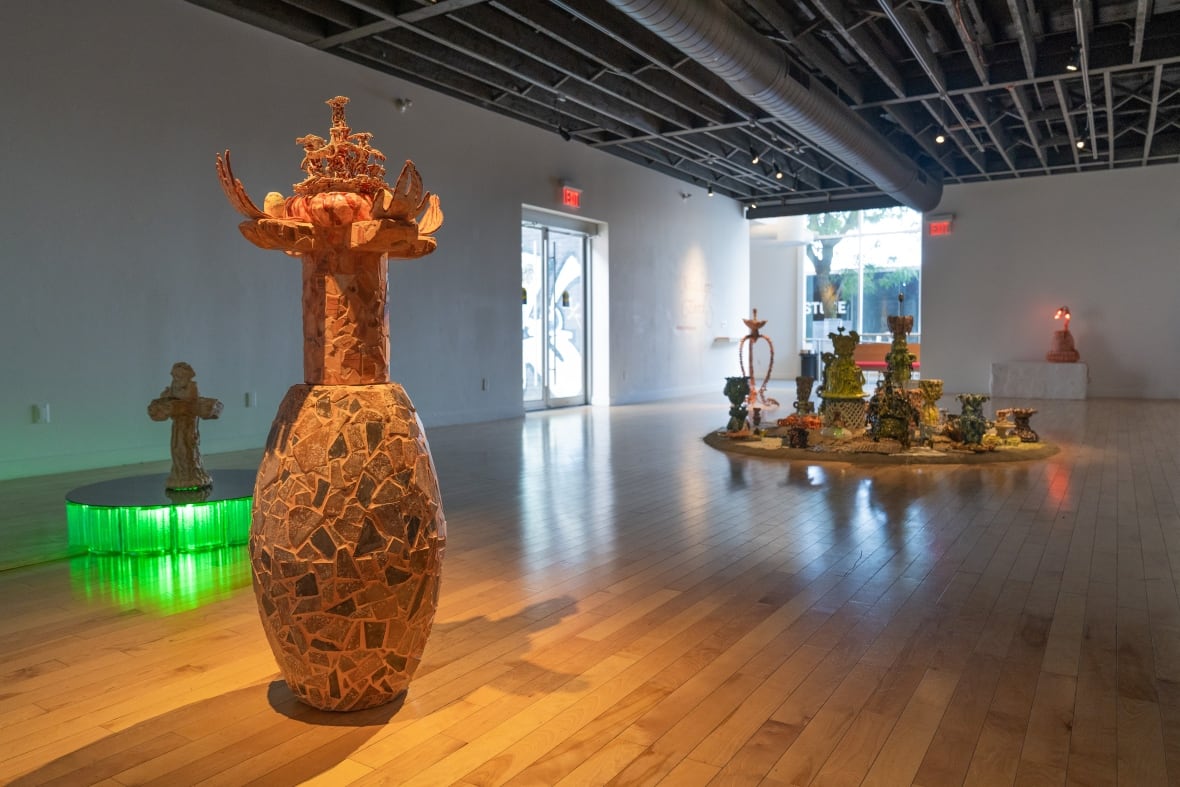 An assortment of large-scale ceramic artworks, some with lights, are installed around an exhibition space. 