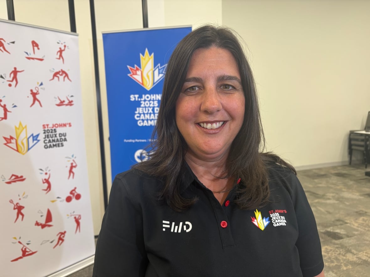 A smiling woman wearing a black polo shirt.