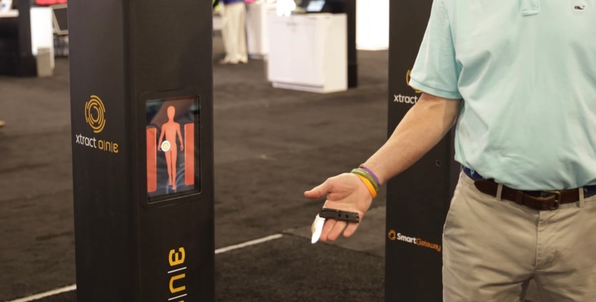 A man holds a pocketknife next to a metal detector.