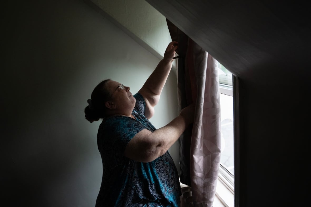 Woman closes curtains