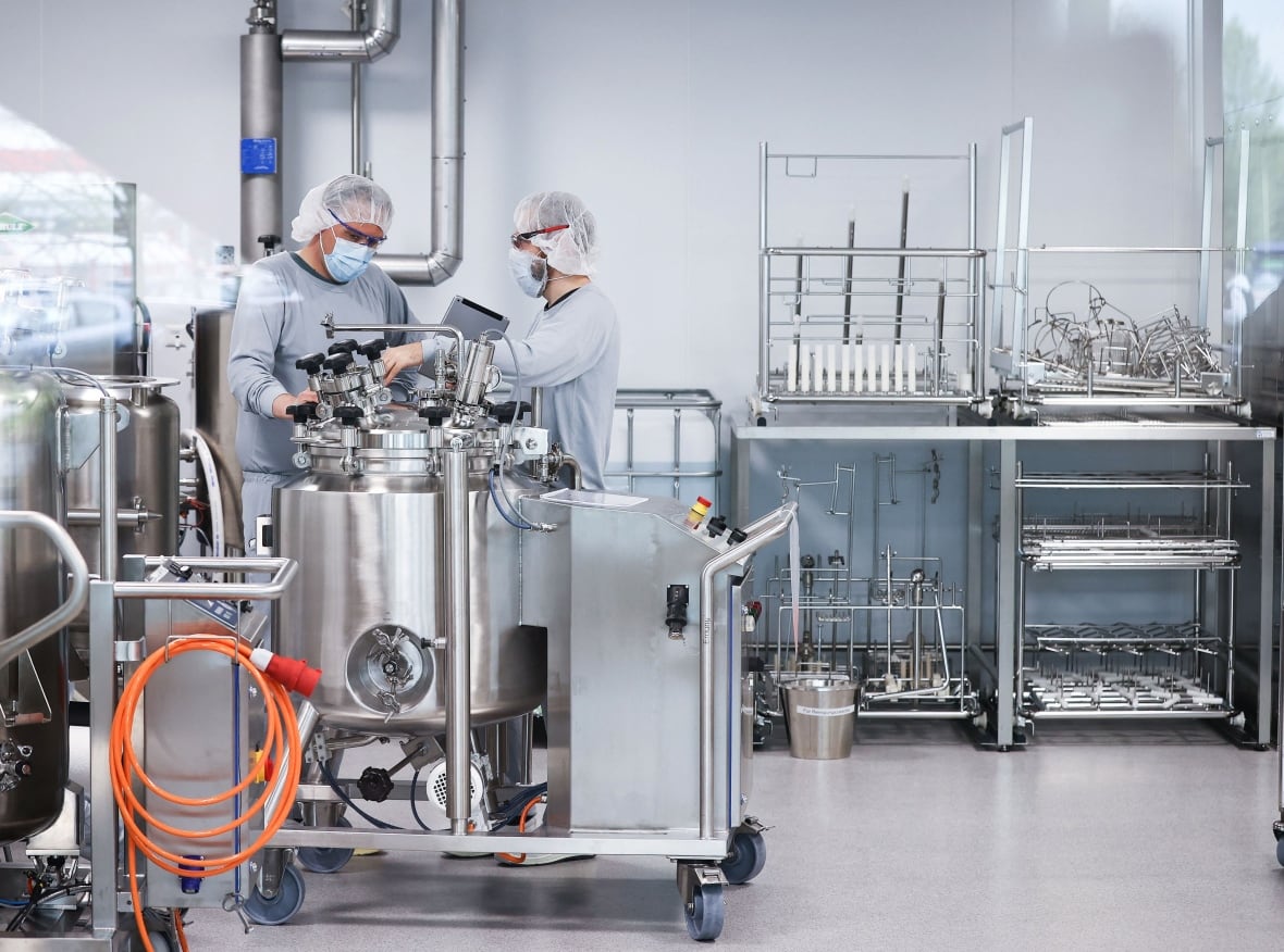 Employees in clean room clothes produce a Pfizer/Biontech vaccine from Communaty Covid-19 near Hamburg, Germany, on April 30, 2021, in the midst of the Corona virus. 