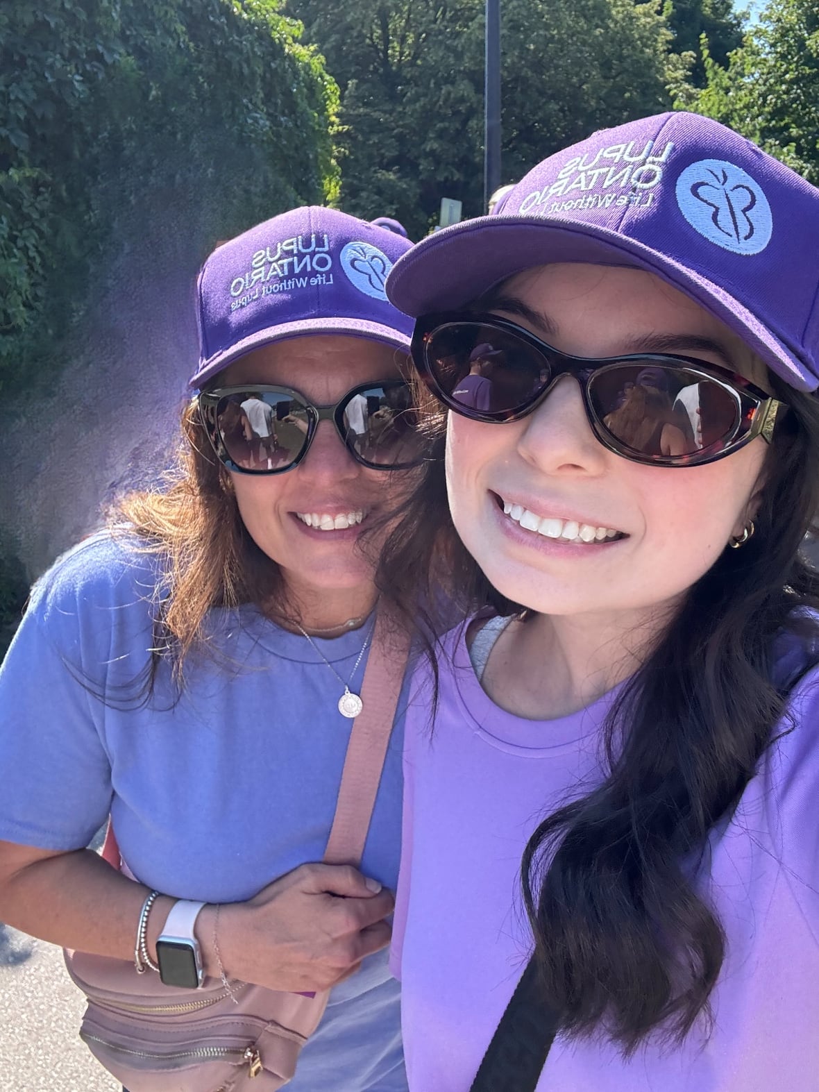 Dos mujeres risas posaron para selfie. Ambos llevan sombreros y camisas de ple da.