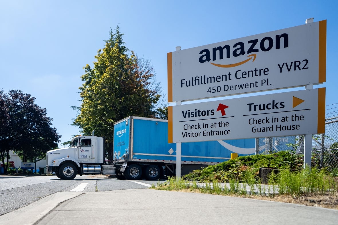 Un camión sale de una instalación, una señal del centro de cumplimiento de Amazon como VVR2.