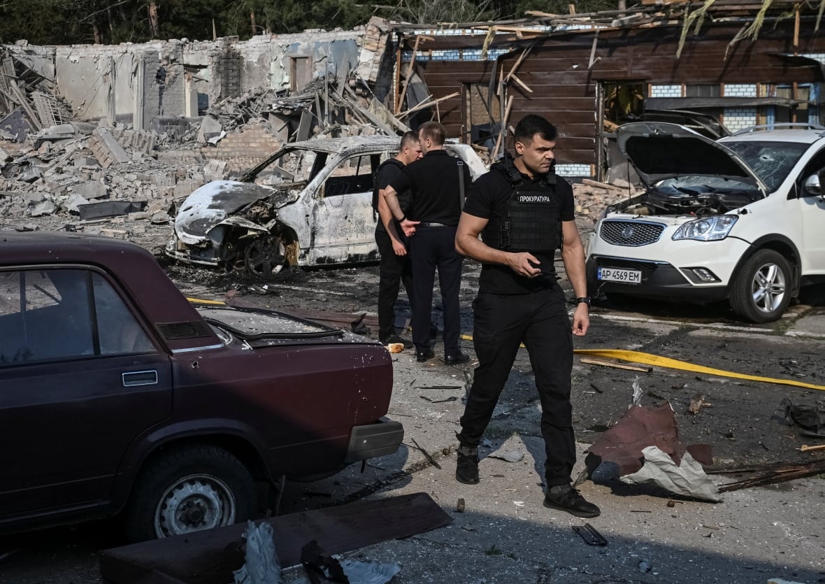 Prosecutors attend the scene of a Russian military strike in Ukraine's Zaporizhzhia region.