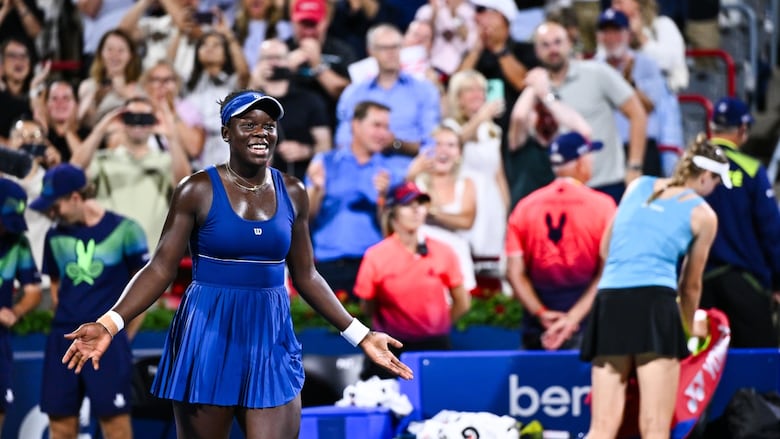 A women's tennis player celebrates her victory.